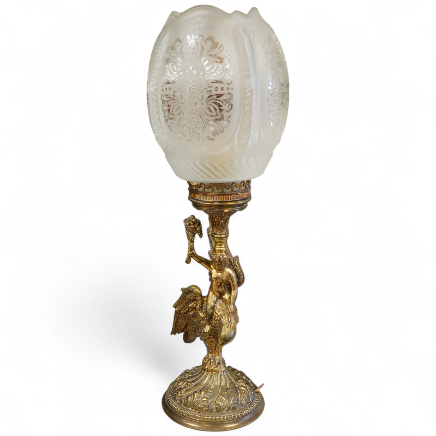 A brass three light table lamp with green toleware shade, another similar table lamp and a brass glass shaded lamp with a putti riding on the back of an eagle, (3)